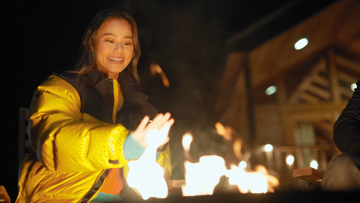 Guest laughing beside the fire during an episode